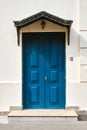 Beautiful blue wooden door against a white wall Royalty Free Stock Photo