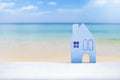 Beautiful blue wooden house model over blurred summer beach background, real estate and property busienss Royalty Free Stock Photo