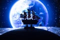 Beautiful boat toy over a blue balll with blurred blue planet and cosmos scene at background Royalty Free Stock Photo