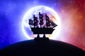 Beautiful boat toy over a blue balll with blurred blue and red planet and cosmos scene at background Royalty Free Stock Photo