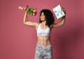 A beautiful body athletic girl with curly hair and in sportswear, holds in a strong muscular arm a bouquet of gentle tulpans