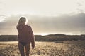 Beautiful body and blonde model walking away and viewed from back side. sunset time and outdoor beach leisure activity for Royalty Free Stock Photo