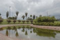 A beautiful bogota metropolitan park scene with water tree reflection and grey cloudy sky