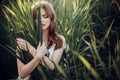 Beautiful boho girl posing in grass at sunset light near lake. a Royalty Free Stock Photo