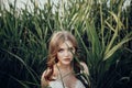 Beautiful boho girl posing in grass at sunset light near lake. a Royalty Free Stock Photo