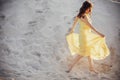 Beautiful boho girl walking on sandy beach at sunset light near Royalty Free Stock Photo