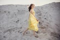 Beautiful boho girl walking on sandy beach at sunset light near Royalty Free Stock Photo