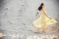 Beautiful boho girl walking on sandy beach at sunset light near Royalty Free Stock Photo