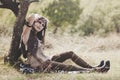 Beautiful Boho style girl resting by the tree in nature