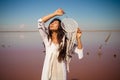 Beautiful boho styled model wearing white on the beach in sunset. Dream catchers blown around by a light sea breeze