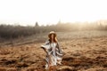 Beautiful boho woman hipster, smiling and standing at sunset in