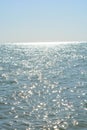 Beautiful border between the blue sky and the black sea with small waves and fine golden and bright reflections of the sun on the Royalty Free Stock Photo