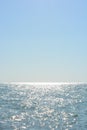 Beautiful border between the blue sky and the black sea with small waves and fine golden and bright reflections of the sun on the Royalty Free Stock Photo
