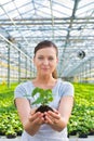 Midsection of beautiful botanist holding seedling in plant nursery