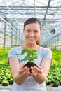 Midsection of beautiful botanist holding seedling in plant nursery