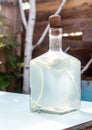 Beautiful bottle with moonshine and horseradish. Homemade alcoholic drink in a decanter