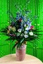 Beautiful bouquet with bloom fresh blue and white flowers in vase on green background Royalty Free Stock Photo