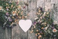 Beautiful bouquet of bright wild flowers with a heart in the form of a note for text on a wooden Board. an image with a soft,