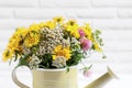 Beautiful bouquet of bright wildflowers in watering can near white brick wall, closeup Royalty Free Stock Photo