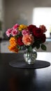 Beautiful bouquet of colorful roses in glass vase on table in home interior Royalty Free Stock Photo