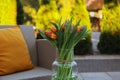 Beautiful bouquet of colorful tulips in glass vase outdoors Royalty Free Stock Photo