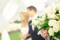 Beautiful bouquet of flowers on the background of a blurred silhouette of a loving couple of bride and groom.