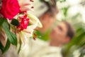 Beautiful bouquet of flowers on the background of a blurred silhouette of a loving couple of bride and groom.