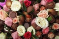 Beautiful bouquet of flowers and chocolate candies as background, closeup Royalty Free Stock Photo