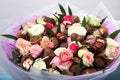 Beautiful bouquet of flowers and chocolate candies on light background, closeup Royalty Free Stock Photo