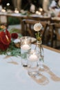 A beautiful bouquet of flowers, glass of candle and glass of flower arranged on the table, for romantic dinner or wedding Royalty Free Stock Photo