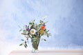 Beautiful bouquet of flowers in glass vase on blue background Royalty Free Stock Photo