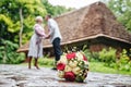 Beautiful bouquet of flowers lying on the ground, on a blurry background of kissing and hugging couple Royalty Free Stock Photo