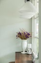 Beautiful Bouquet of Flowers in White Shiny Ceramic Flowerpot on Rustic Wooden Table at The Corner of Luxury White Living Room