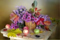 Still life with autumn leaves and september pink, blue tones in a basket on a brown background Royalty Free Stock Photo