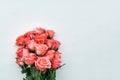 Beautiful bouquet of fresh coral roses in full bloom on white wooden background