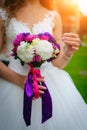 Beautiful bouquet of fresh flowers in the hands of bride in white dress. Wedding flowers close-up Royalty Free Stock Photo