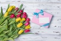 Beautiful bouquet of fresh yellow and pink tulips with gift box and card Royalty Free Stock Photo