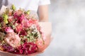 Beautiful bouquet of mixed flowers in female hands. roses, eustomas, alstroemerias. Royalty Free Stock Photo