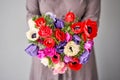 Beautiful bouquet of multicolored anemones in woman hand. the work of the florist at a flower shop. A small family