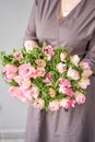 Beautiful bouquet of pink anemones in woman hand. the work of the florist at a flower shop. A small family business