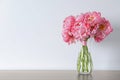 Beautiful bouquet of pink peonies in vase on table against white background. Space for text Royalty Free Stock Photo