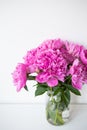 Beautiful bouquet of pink peony flowers in a vase on a white table. Flower surprise on March 8 Royalty Free Stock Photo