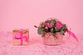 Beautiful bouquet of pink roses and eucalyptus branches in a gift basket on a pink background with confetti Royalty Free Stock Photo