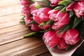 Beautiful bouquet of pink tulips on wooden table, close up