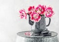 Beautiful bouquet of pink and white filled tulip flowers in an old vintage enamel teapot.