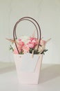 Beautiful bouquet of pink and white peony roses flowers in paper bag on white background Royalty Free Stock Photo