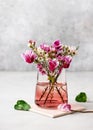 Beautiful bouquet of pink, white wax flower and purple cyclamen flowers in a glass vase.