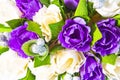 A beautiful bouquet of purple and yellow roses, green leaves and silver berries. Top view. Close-up Royalty Free Stock Photo