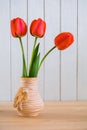 Beautiful bouquet of red tulips in a vase on the table. Still life