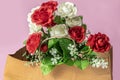 Beautiful bouquet of red and white roses in a paper bag on a pink background Royalty Free Stock Photo
